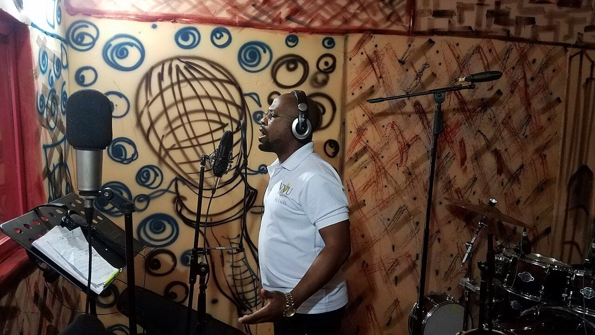 A radio presenter speaking into a microphone in a studio